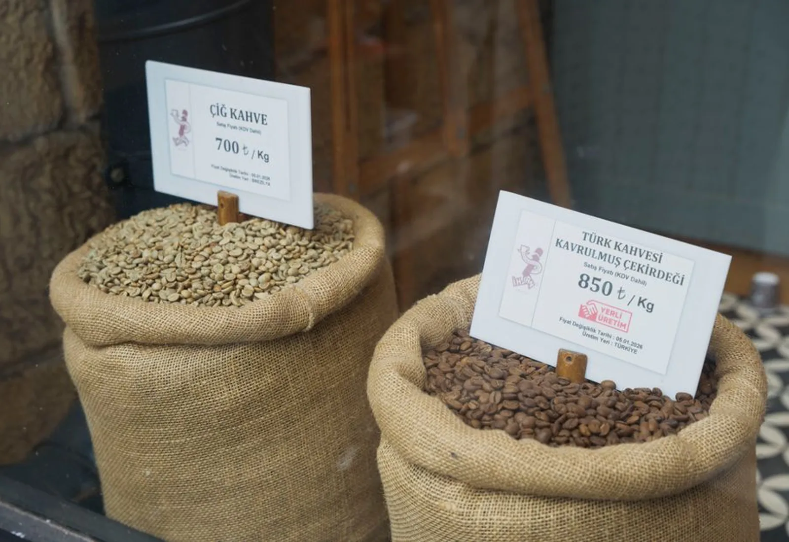 Open burlap sacks of pale green unroasted coffee beans