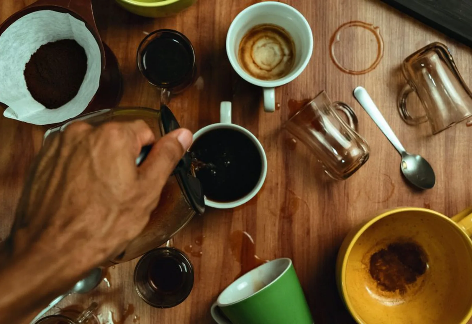 A cupping table set with rows of cups and tasting spoons