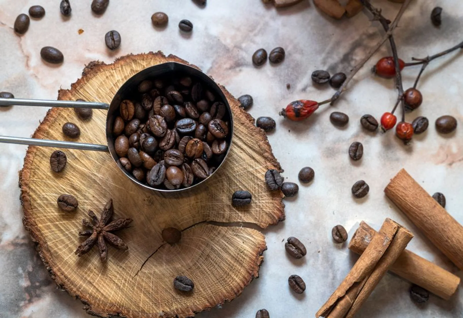 Roasted beans in a copper measure on a rustic wooden round