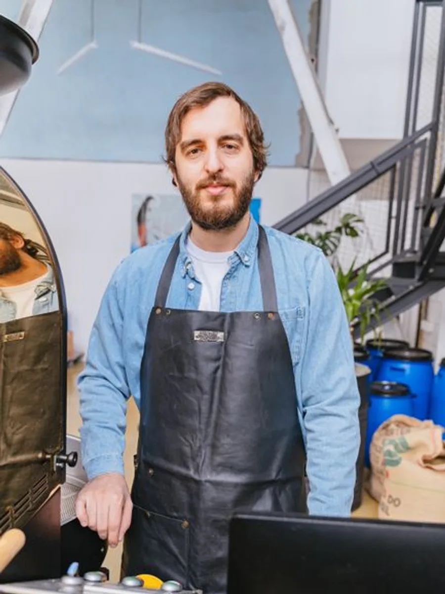 Marcus, founder and head roaster, in an apron behind the bar