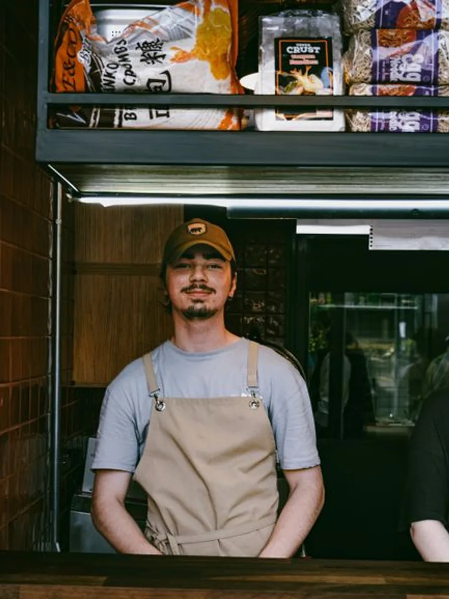 Theo, wholesale lead, in an apron in the roastery
