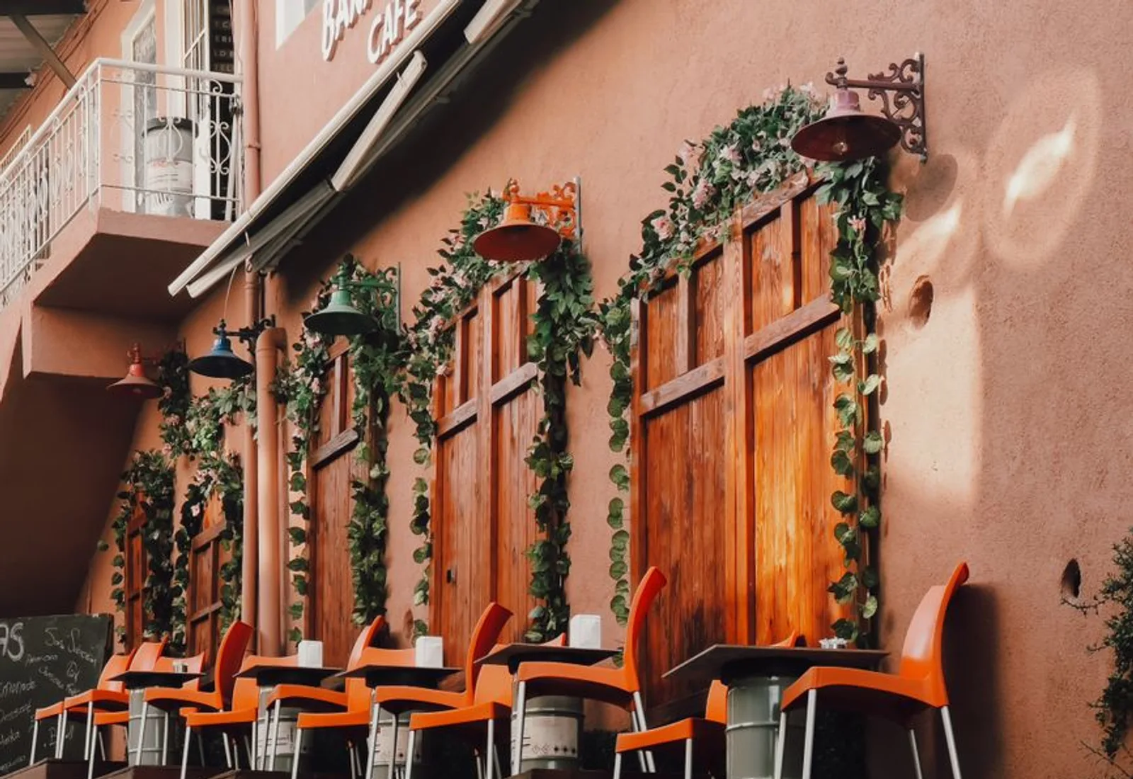 Outdoor seating along a wall trailing with greenery