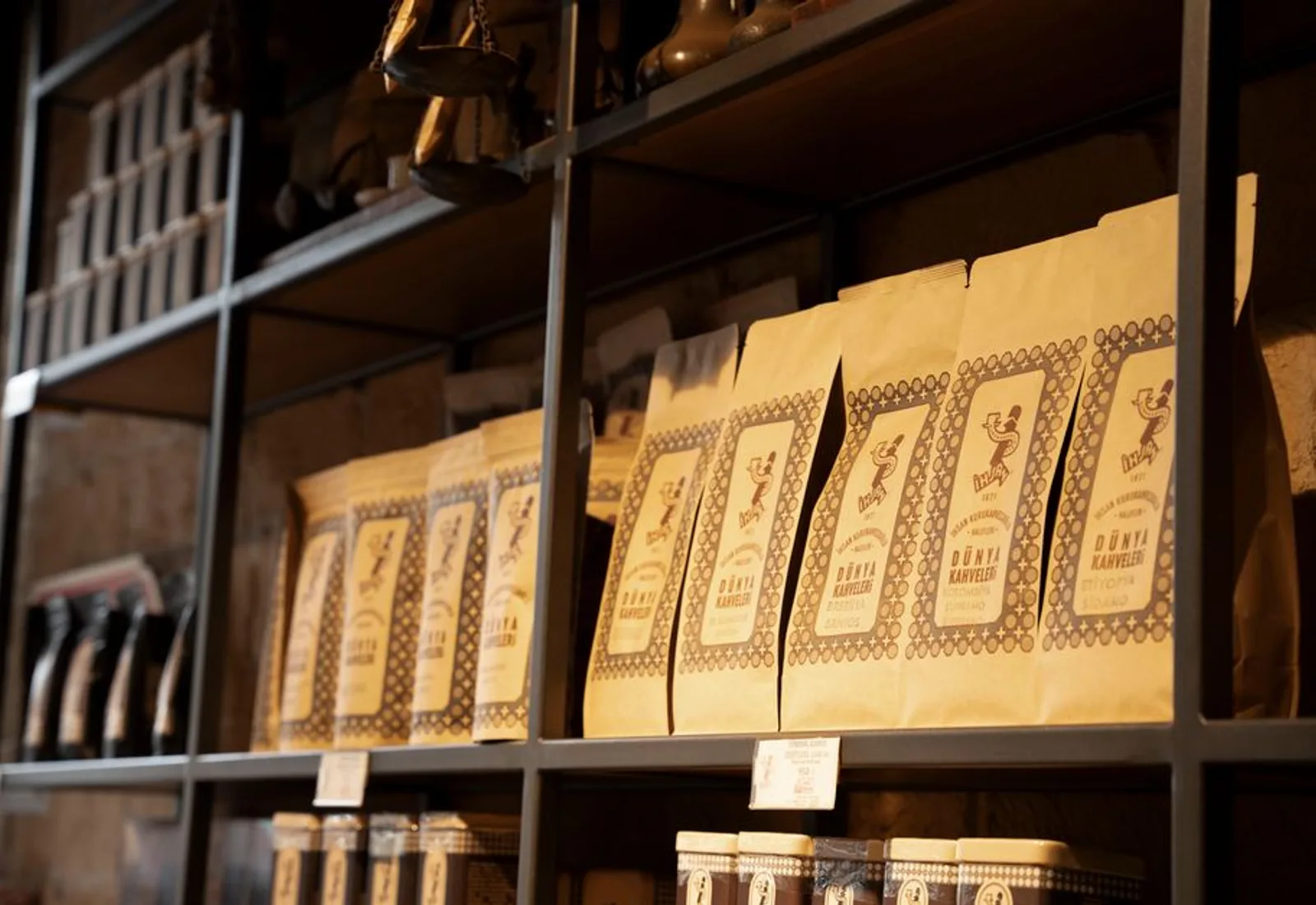 Shelves lined with rows of coffee bags along a dark wall